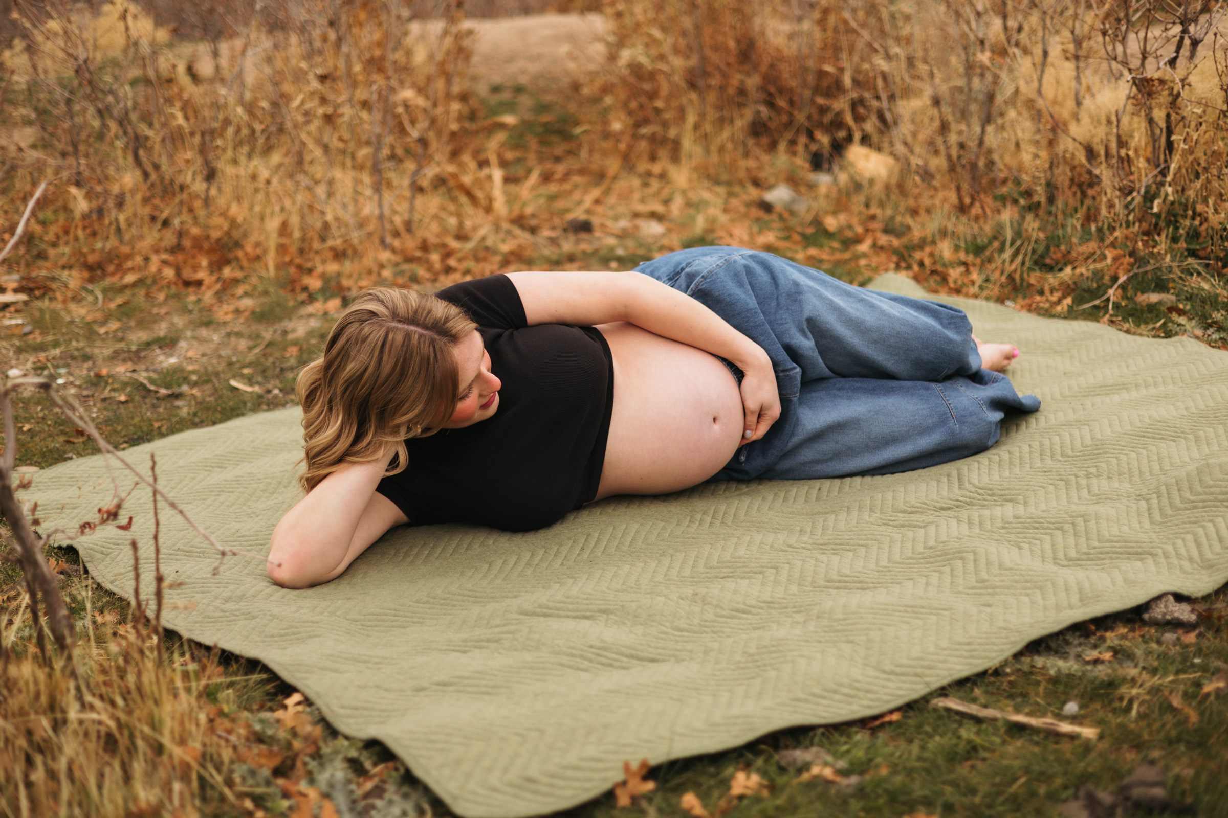 Confident maternity pose woman laying down holding pregnant belly