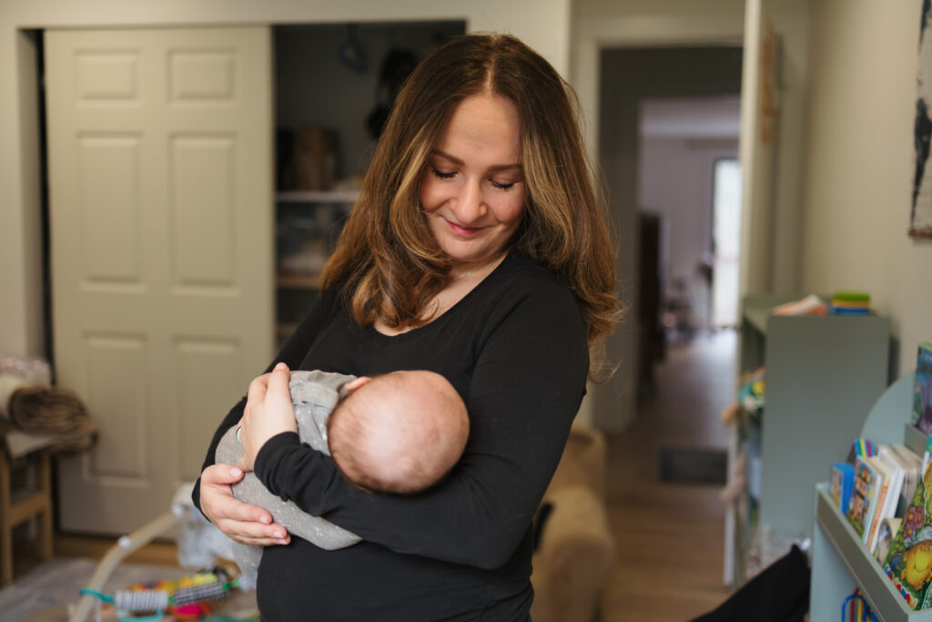 Mother holding and looking down at newborn Seattle WA Mom community