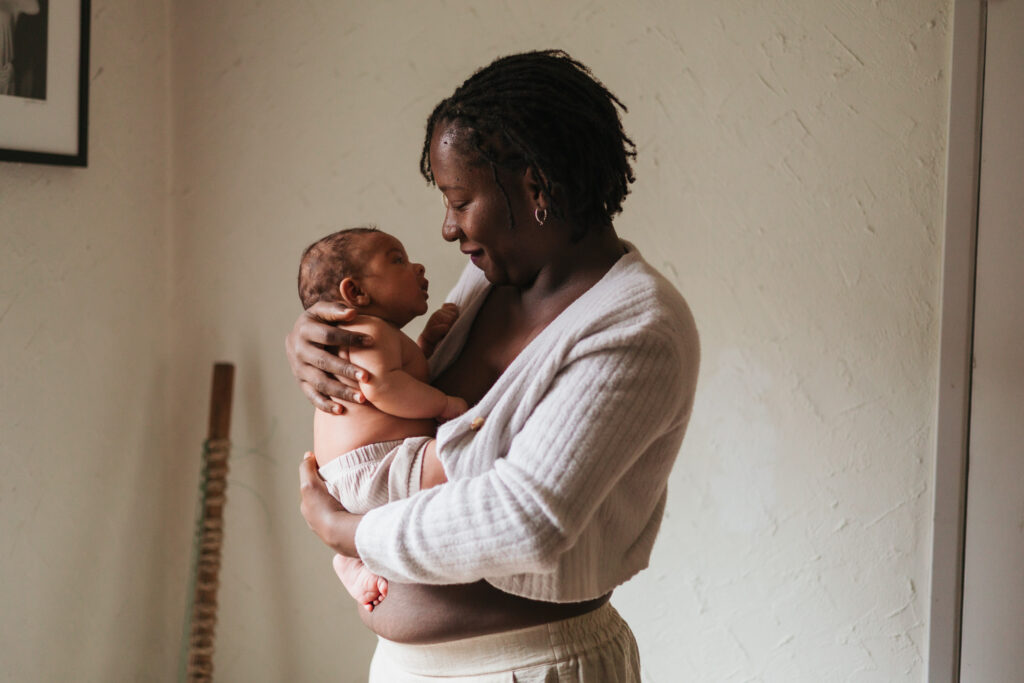 Mom holding newborn and looking at each other in kirkland WA