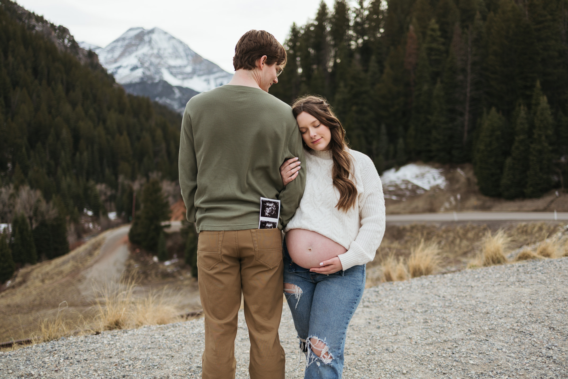 woman holding pregnant belly and husband arm with ultrasound in pocket Bellevue